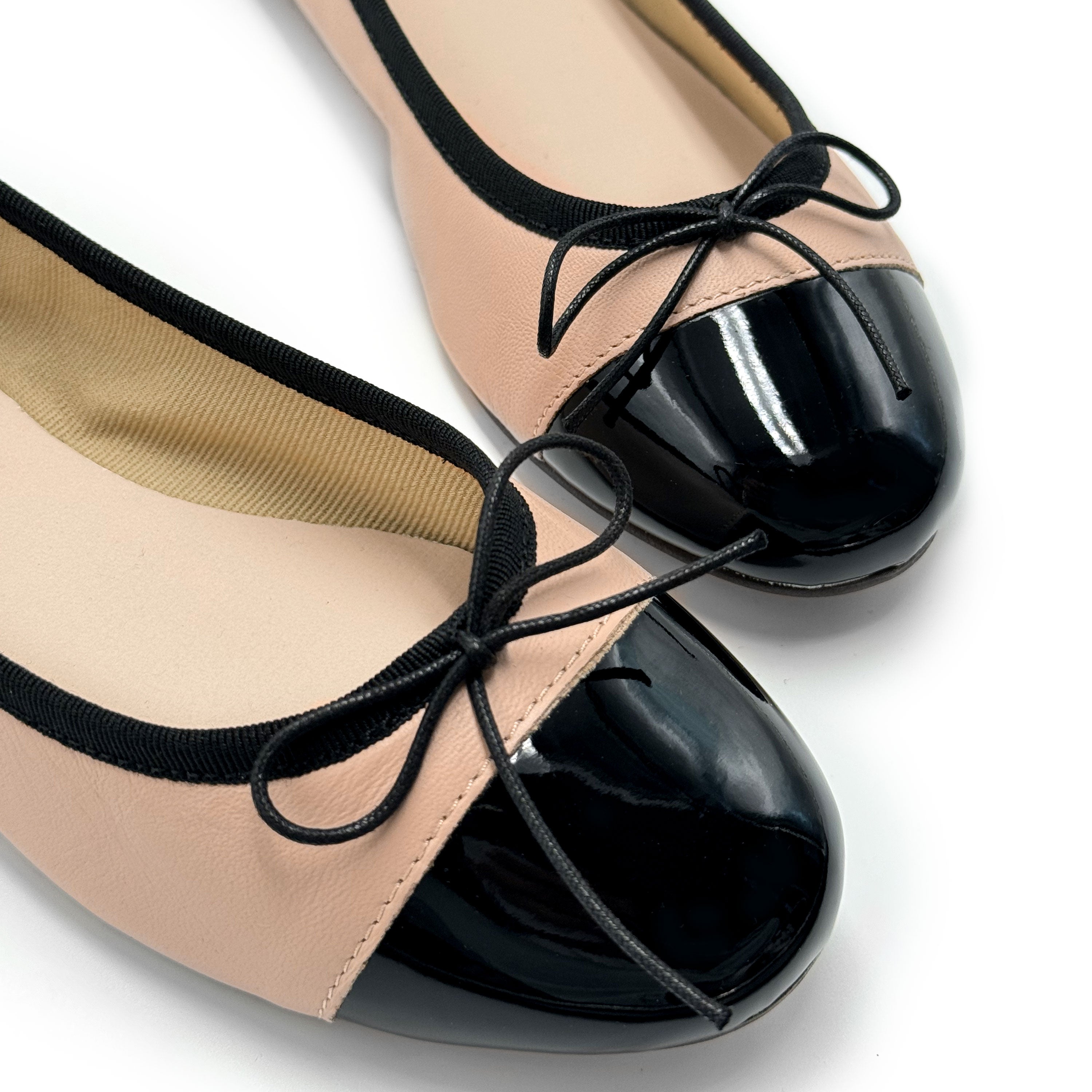 Blush pink leather ballet flats with black patent toe