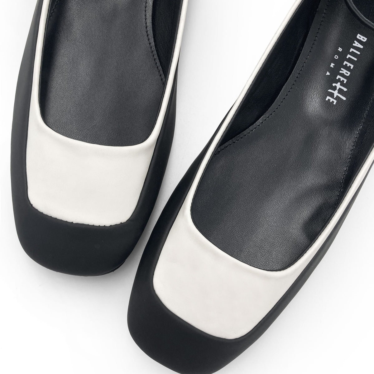 Ballerinas aus zweifarbigem gummiertem Material in Weiß und Schwarz mit Knöchelriemchen