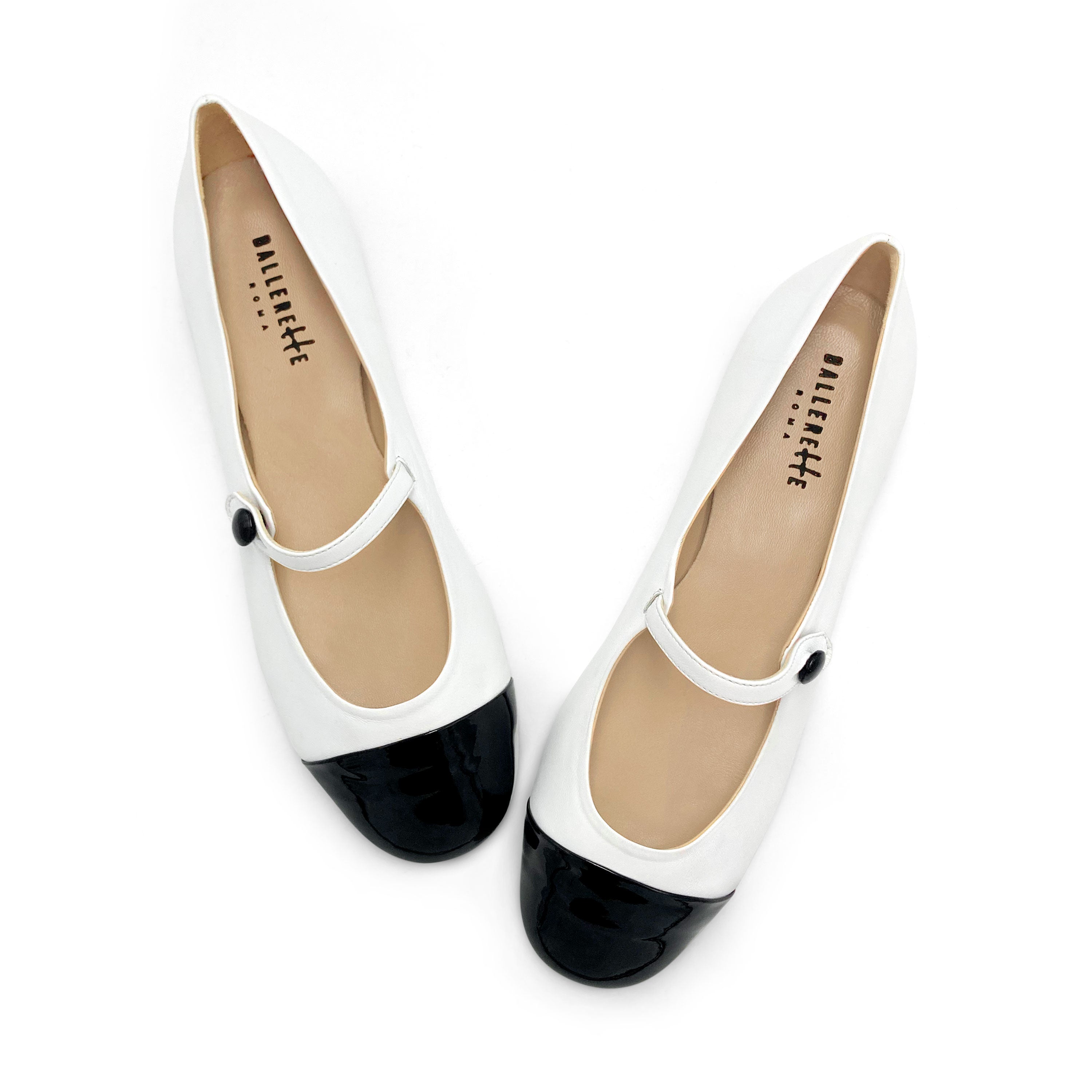 White ballet flats with black patent toe and strap