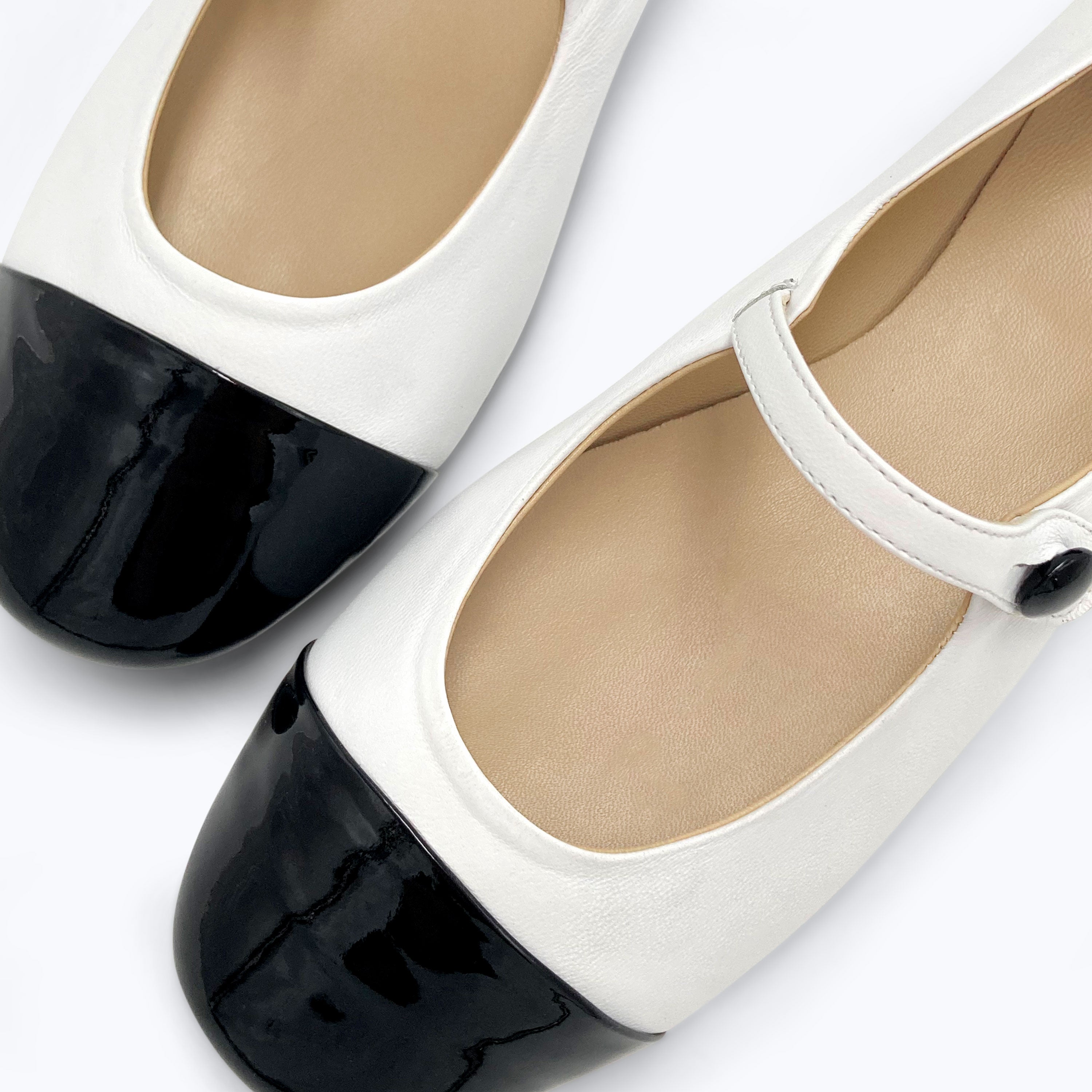 White ballet flats with black patent toe and strap