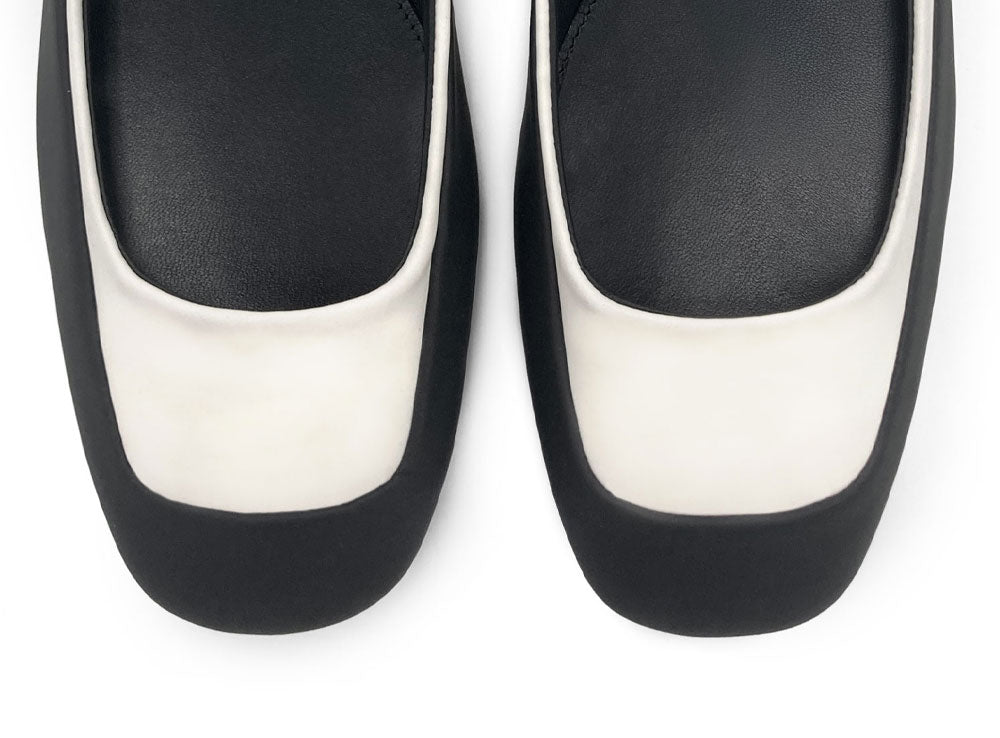 Ballerinas aus zweifarbigem gummiertem Material in Weiß und Schwarz mit Knöchelriemchen