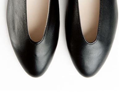Hochgeschlossene schwarze Ballerinas